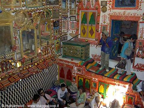 Tourists inside the ornate room covered with mirrors and colorful fabrics