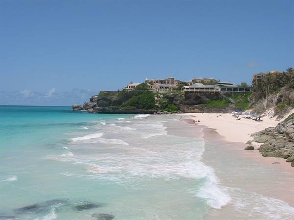 Pink sand beach with turquoise waves and hotels on the cliff, Crane Beach