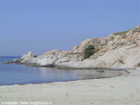 White sand beach with smooth granite rocks and calm turquoise sea