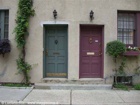 Two colored doors, green and purple, on stucco facade with lanterns