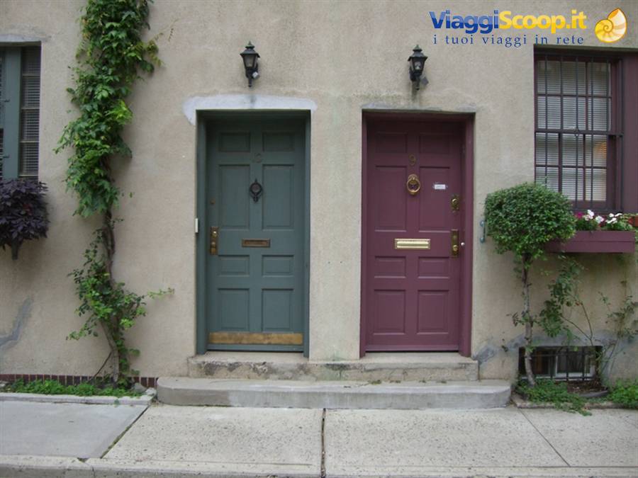 Two colored doors, green and purple, on stucco facade with lanterns