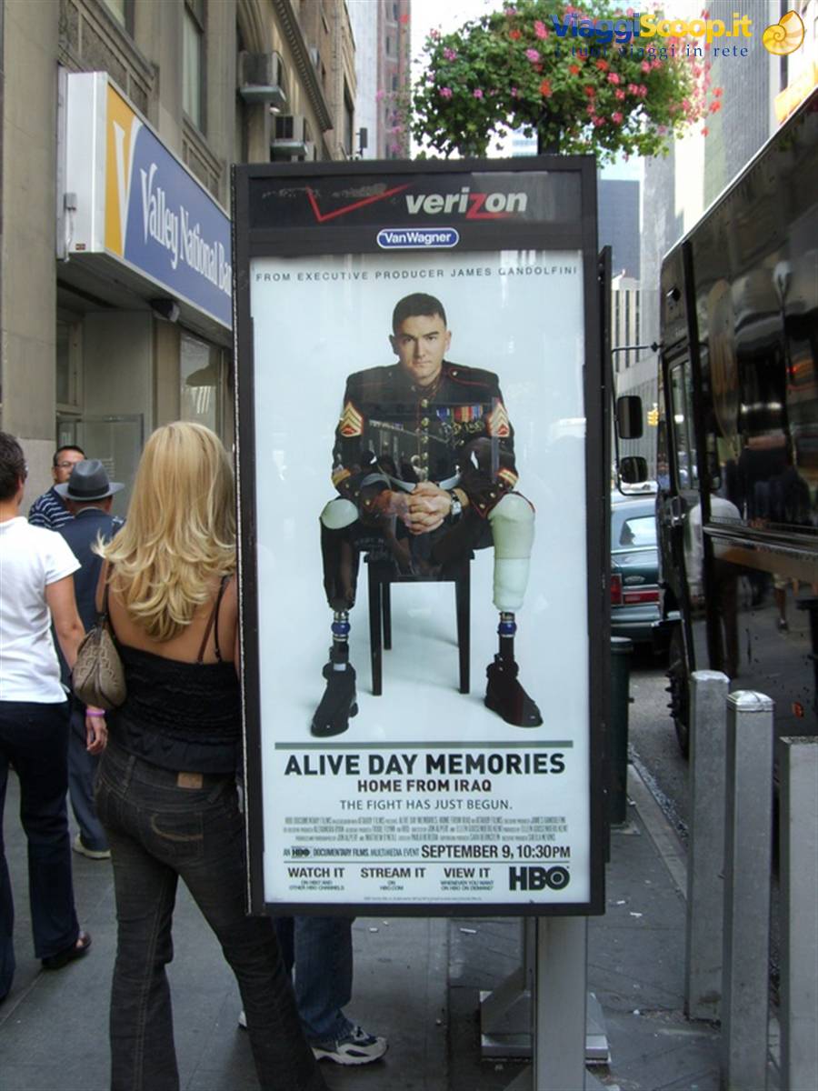 Blonde woman looking at HBO poster of wounded marine on a New York street