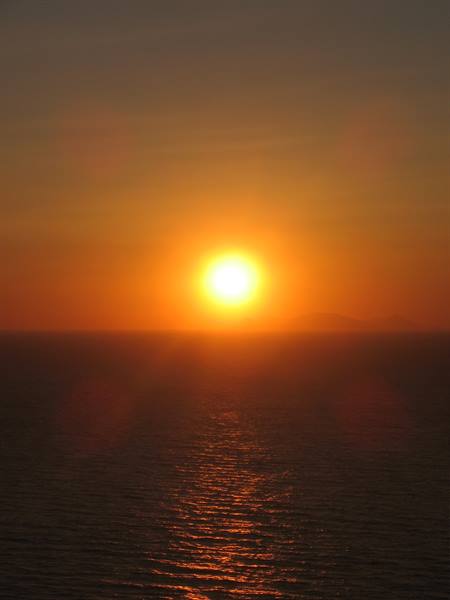 Low sun over the sea horizon, golden reflections on the waves