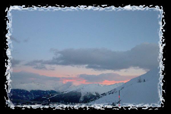 Snowy peaks glowing under pink evening sky