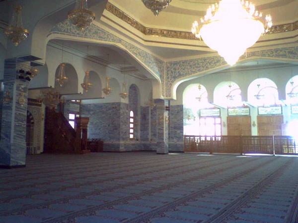 Prayer hall with golden chandeliers, blue marble walls and striped carpets