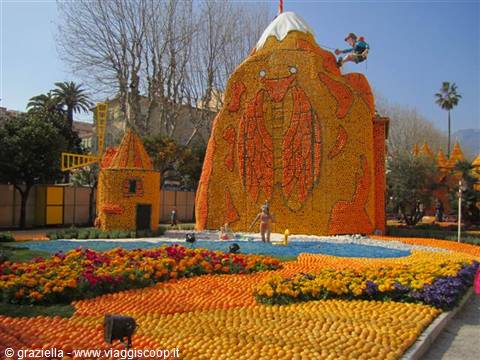 Citrus fruit sculptures shaped like mountain and house, lemon festival, flower beds