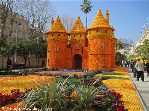 Citrus castle at Menton Lemon Festival, surrounded by flower beds