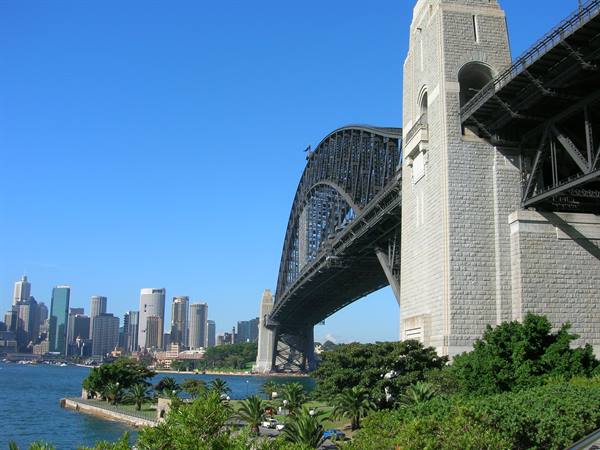 Sydney Harbour Bridge, granite pylon and steel arch against a clear blue sky