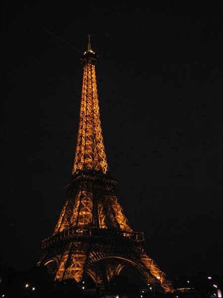 The Eiffel Tower glowing golden against the dark night sky