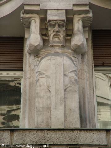 Male stone caryatid lifting the beam above the window