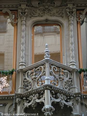 Ornate carved stone balcony with floral Art Nouveau motifs in daylight