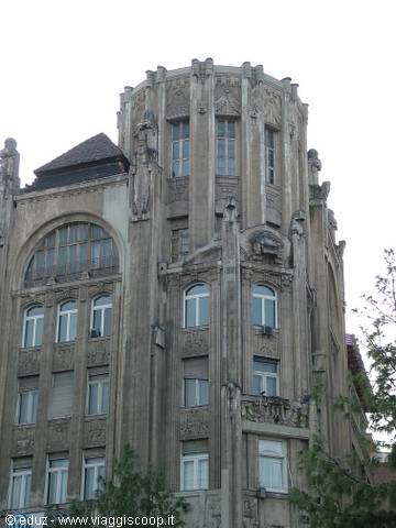 Art nouveau building in Budapest, grey stone facade with statues and carved balconies