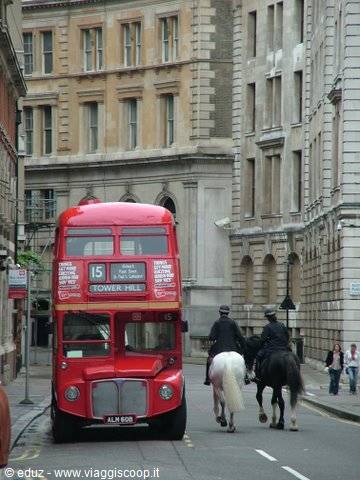 Red double-decker bus route 15 and mounted police riders in London