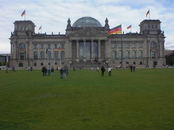 Tourists on the lawn in front of Berlin's Reichstag with German flags