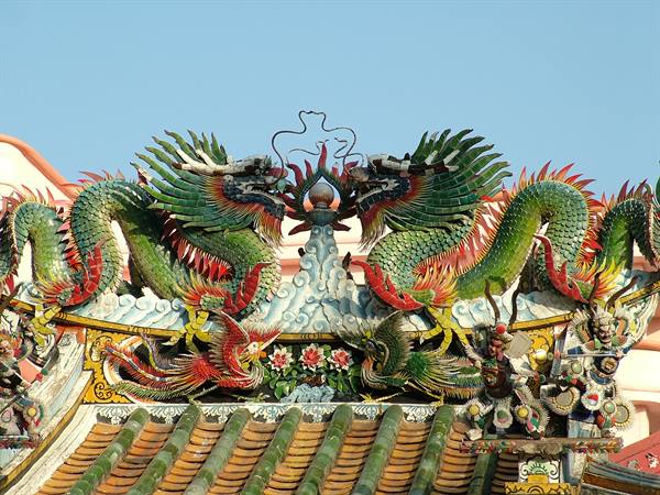 Colorful ceramic dragons and phoenixes decorate a temple roof