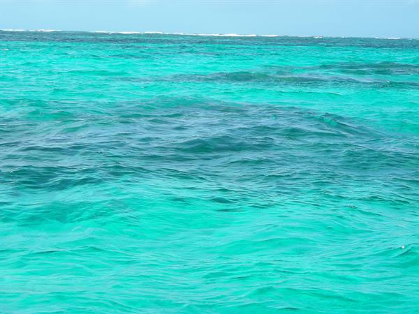 Turquoise Caribbean sea with gentle waves and reef in the distance