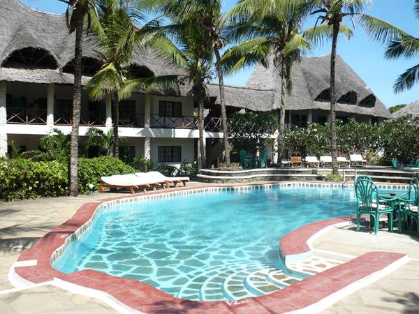 Red-edged pool surrounded by palms and thatched-roof bungalows