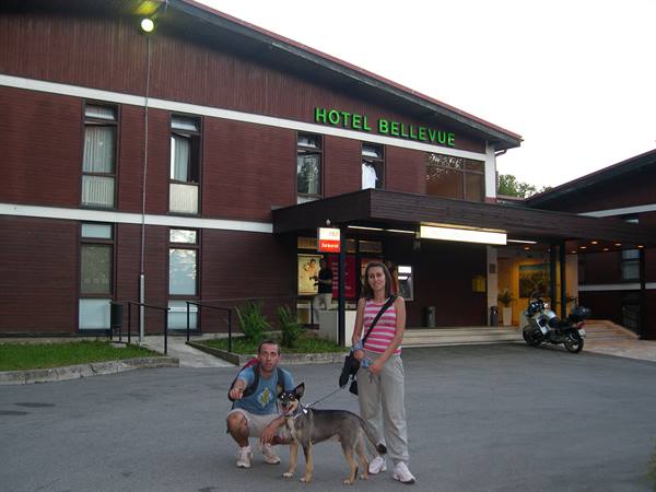 Couple with dog standing outside the wooden Hotel Bellevue entrance