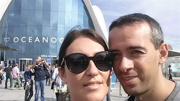 Selfie in front of Valencia's Oceanogràfic, curved blue glass facade, tourists around