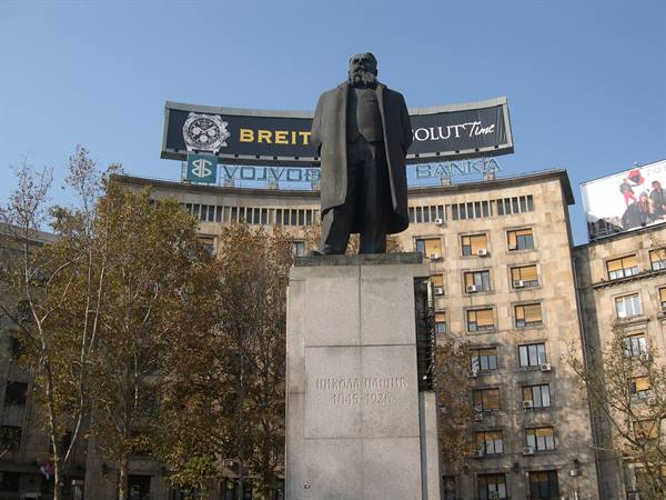 Bronze statue of Nikola Pašić on stone pedestal before the former Vojvođanska banka building
