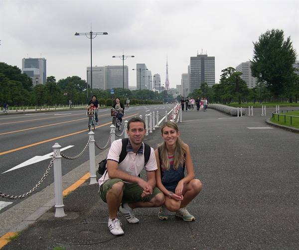Couple crouching on a Tokyo avenue, Tokyo Tower in the background