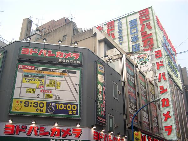 Yodobashi Camera signs in Shinjuku, buildings covered with red and white Japanese signs