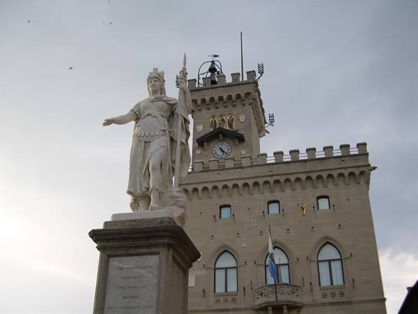 Marble statue of Liberty in front of San Marino's Palazzo Pubblico under gray sky