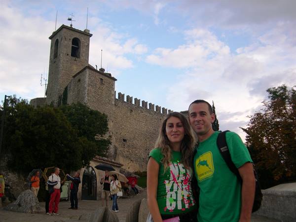 Couple in green shirts in front of San Marino's Guaita fortress