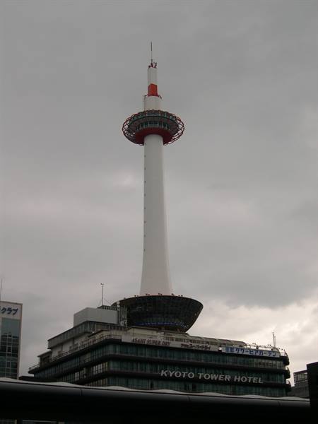 White and red Kyoto Tower above the hotel, gray cloudy sky