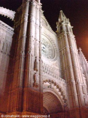 Palma Cathedral at night: gothic stone facade with illuminated rose window
