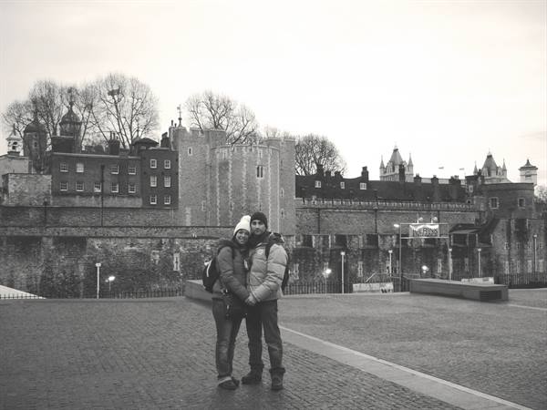 Couple embracing in front of the Tower of London stone walls, black and white photo