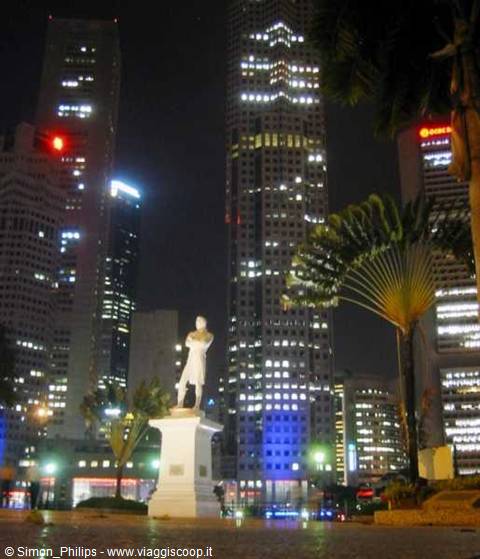 Raffles statue lit among Singapore skyscrapers at night