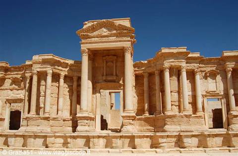 Roman theatre of Palmyra: limestone stage facade under clear blue sky