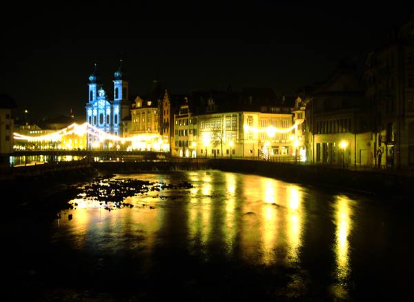 Jesuit Church lit in blue over the Reuss river, Lucerne at night