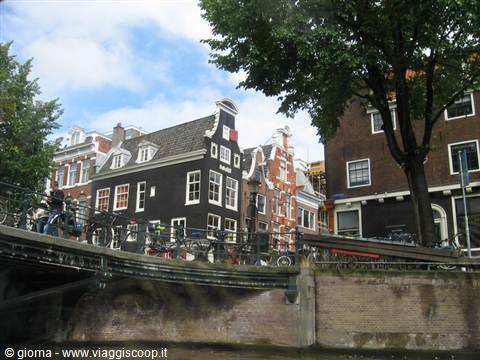 Leaning brick canal houses in Amsterdam, bicycles on the bridge
