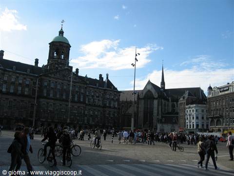 Tourists and cyclists on Dam Square in Amsterdam, by the Royal Palace