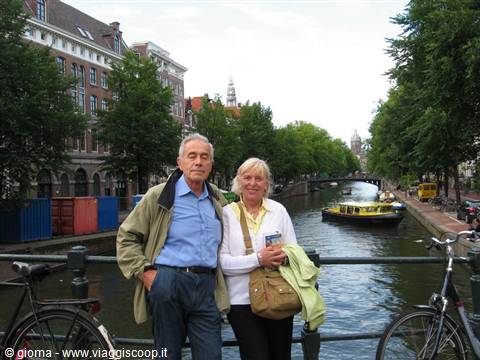 Couple on a bridge among bicycles along Amsterdam canal