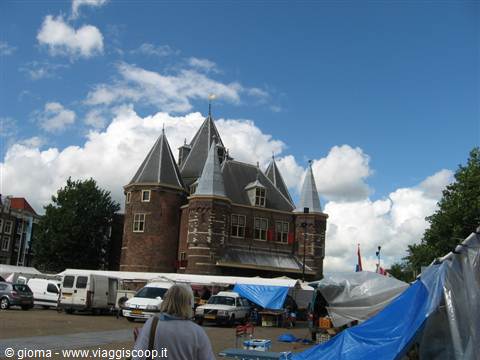 The Waag in Amsterdam, old brick building with towers, above a market with vans