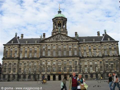 Tourists walk in front of the Royal Palace on Dam Square, Amsterdam