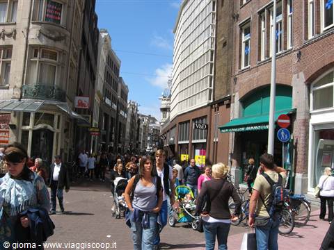 Crowded shopping street with pedestrians, brick buildings and parked bicycles