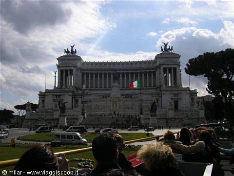 Tourists photographing Rome's Vittoriano marble monument against backlit clouds