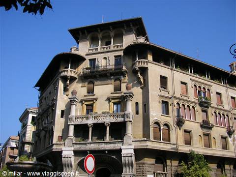 Art Nouveau stone building with balconies and arched windows under blue sky