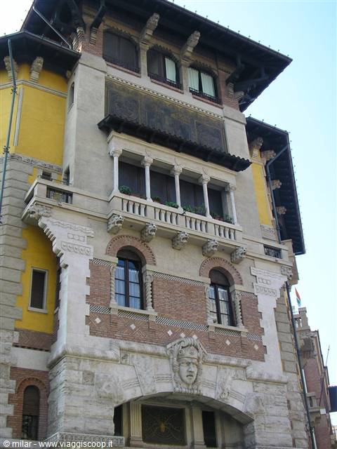 Art Nouveau facade with brick, yellow stone and arched balcony
