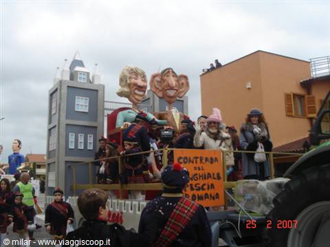 Satirical carnival float with giant caricature figures, costumed crowd watching, Viareggio