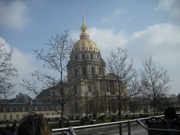 The golden dome of Les Invalides in Paris seen through bare trees
