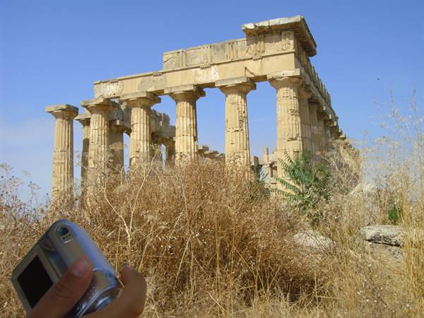 Hand holding camera before the Doric columns of Selinunte temple