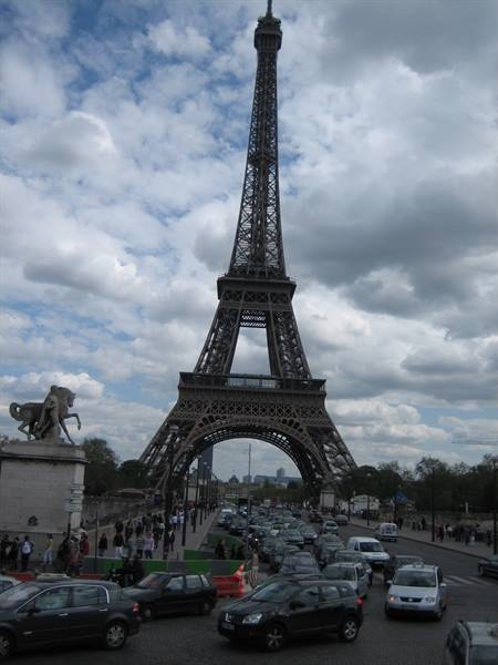 Crowds and cars fill the Pont d'Iéna beneath the iron Eiffel Tower