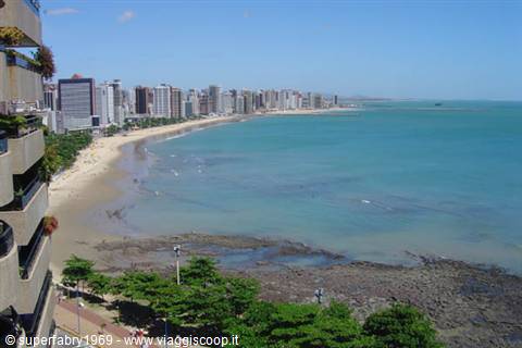 High-rise skyline over Boa Viagem beach in Recife, reef rocks in foreground