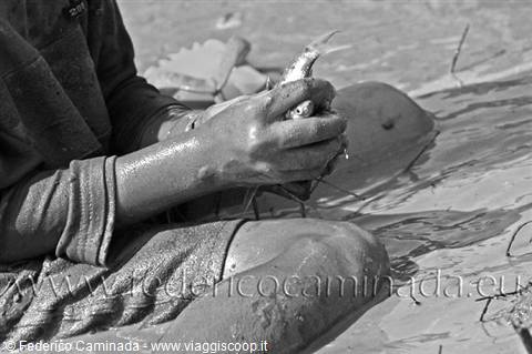 Child sitting in the mud with dirty hands