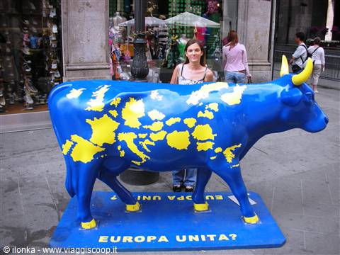 Woman beside blue plastic cow painted with yellow Europe map, Europa Unita?